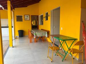 a dining room with yellow walls and a table and chairs at Chácara Vista do Pico Agudo in Lavrinhas