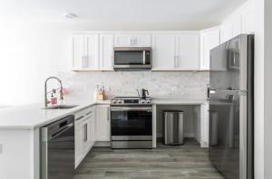 ニューヘイブンにあるDowntown 2BR Gem Yale Wooster Sq WiFiの白いキャビネットとステンレス製の電化製品を備えたキッチン