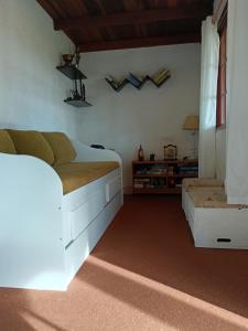 une chambre avec un lit blanc et un canapé dans l'établissement La casa del agua, à La Pedrera