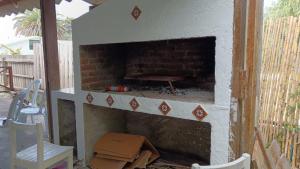 une cheminée en briques avec une chaise et quelques boîtes dans l'établissement La casa del agua, à La Pedrera