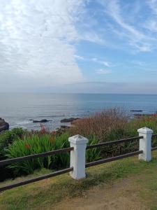 une clôture en bois au bord de l'océan, sur une falaise dans l'établissement La casa del agua, à La Pedrera