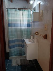 une salle de bain avec un rideau de douche et un lavabo dans l'établissement La casa del agua, à La Pedrera