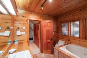 a bathroom with a bath tub and a sink at Heron Chalet by Outpost Whistler in Whistler +64 photos