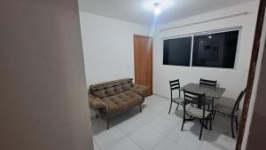 ein Wohnzimmer mit einer Couch und einem Tisch mit Stühlen in der Unterkunft Apartamento Mobiliado! in João Pessoa + 5 Fotos