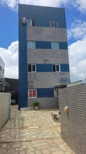 ein hohes blaues Gebäude mit einem Steinhof davor in der Unterkunft Apartamento Mobiliado! in João Pessoa
