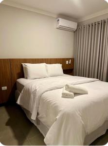 Un dormitorio con dos camas con sábanas blancas. en Apartamento aconchegante próximo ao mar em Itapoá, en Itapoa