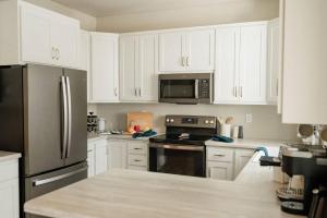 una cucina con mobili bianchi e un frigorifero in acciaio inossidabile di Prinsen Retreat a Ellison Bay