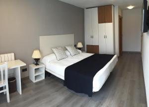 a bedroom with a large white bed and a desk at Hosteria La Moraleja in Solares