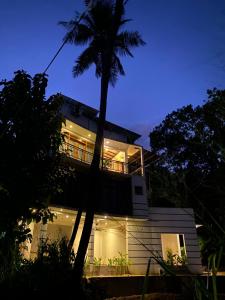 a house with a palm tree in front of it at The Paddy View Villa in Dickwella +34 photos