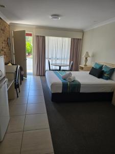 a hotel room with a large bed and a window at Crows Nest Motel in Crows Nest
