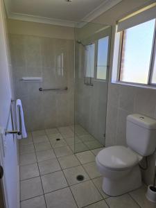 a bathroom with a toilet and a glass shower at Crows Nest Motel in Crows Nest +46 photos