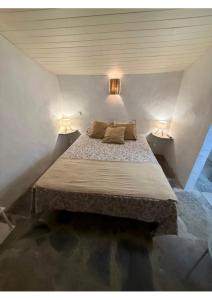 Una cama grande en una habitación con dos lámparas. en Casa Tia Anica I, en Monsaraz