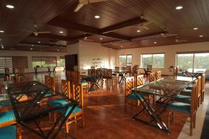 a dining room with tables and chairs and windows at Winspark Inn Resort in Varkala