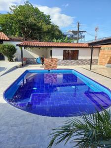 a swimming pool with blue tiles in front of a house at Casa Bella in Rivera