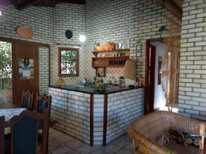 a kitchen with a counter in a brick wall at Casa Sol e Mar in Bombinhas