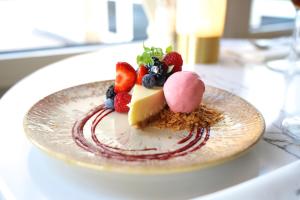 a plate with a dessert with berries on it at HOTEL ALKMAAR - Bar & Restaurant - Meeting & Events in Alkmaar