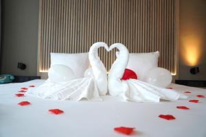 two white swans making a heart on a bed at HOTEL ALKMAAR - Bar & Restaurant - Meeting & Events in Alkmaar