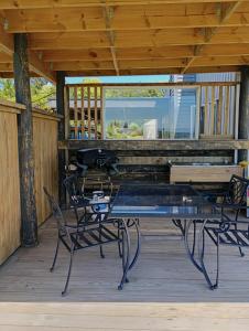 a patio with a glass table and chairs on a porch at Pahoia Pitstop in Tauranga