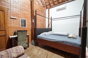 a bedroom with a bed and a chair in it at Villa Roemah Restoe Kolam Renang Private in Beran-kidul +40 photos