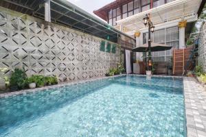 a swimming pool in front of a building at Villa Roemah Restoe Kolam Renang Private in Beran-kidul