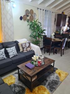 a living room with a couch and a coffee table at Home to Comfort in Old Harbour