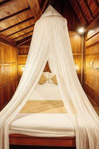 - un lit avec moustiquaire dans l'établissement Kalyana Gangga, à Krambitan