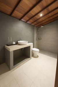 une salle de bain avec un lavabo et des toilettes dans l'établissement Kalyana Gangga, à Krambitan