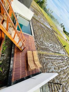 un groupe de chaises assises sur une terrasse dans l'établissement Kalyana Gangga, à Krambitan