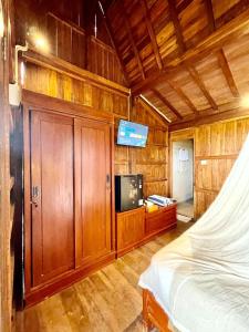 une chambre avec un lit et une télévision à écran plat dans l'établissement Kalyana Gangga, à Krambitan