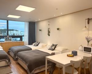 a hotel room with two beds and a table at Hongdae sub 1min in Seoul