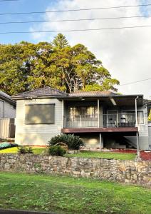 a house with a balcony and a tree at Charlestown Central 7 Bedrooms Front House and Back Unit in Charlestown