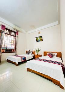 マイチャウにあるMai Ha Backpackers Hostel & Garden Loungeのベッド2台と窓のある寝室 +20枚の写真