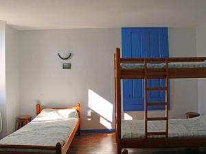 1 Schlafzimmer mit 2 Etagenbetten und einer blauen Tür in der Unterkunft Grand Gîte à La Chabanne - Jusqu'à 14 pers, Animaux admis, Parking, Wifi - FR-1-489-340 in La Chabanne