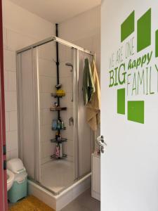 a shower in a bathroom with a sign on the door at AECOspires CoWorkStel in Munich