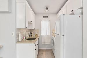 a kitchen with white cabinets and a refrigerator at Downtown location Near the Beach Dog Friendly in Edmonds +11 photos