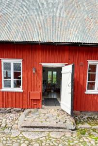 un granero rojo con una puerta y ventanas blancas en Historic Halland Farm Near The Sea In Bua, en Väröbacka