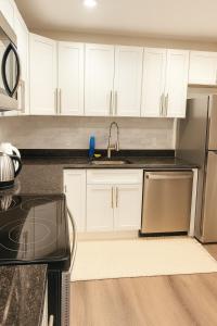 a kitchen with white cabinets and a sink at Modern 2BR Westville Downtown Near Yale Wifi in New Haven