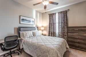 a bedroom with a bed and a chair and a ceiling fan at Nic's Home in Visalia