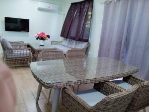 a dining room with a glass table and chairs at Alec's Hotel in Apia