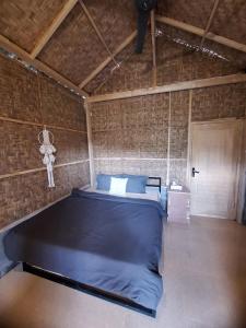 ein Schlafzimmer mit einem großen Bett in einer Ziegelwand in der Unterkunft Penempuran cottage in Masbagik
