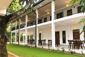 een blik op de binnenplaats van een huis met tafels en stoelen bij The Mammoth udawalawe in Udawalawe