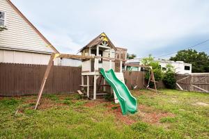 a playground with a green slide in a yard at Light & Cozy Oasis in Jacksonville