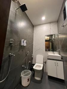 a bathroom with a toilet and a shower and a sink at Yatram in Rishīkesh