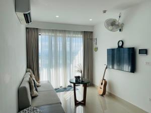 a living room with a couch and a guitar at Beer Homestay Nera Garden Hue in Hue