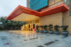 a building with potted plants in front of it at Radisson RED Indore in Indore