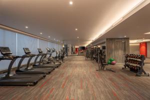 a gym with treadmills and elliptical machines at Radisson RED Indore in Indore