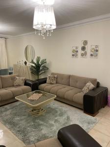 un salon avec un canapé et une table dans l'établissement شقة فاخرة, à Madinaty