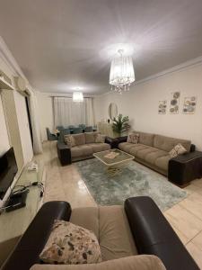 un grand salon avec des canapés et une télévision dans l'établissement شقة فاخرة, à Madinaty