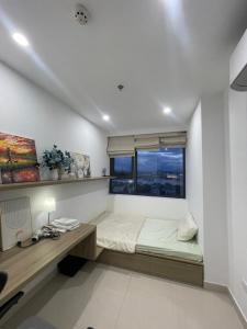 a bedroom with a bed and a desk and a window at Beer Homestay Nera Garden Hue in Hue