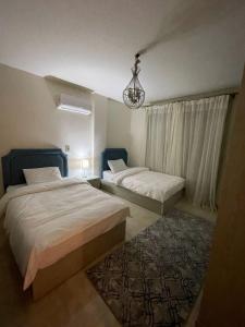 une chambre avec deux lits et un tapis dans l'établissement شقة فاخرة, à Madinaty